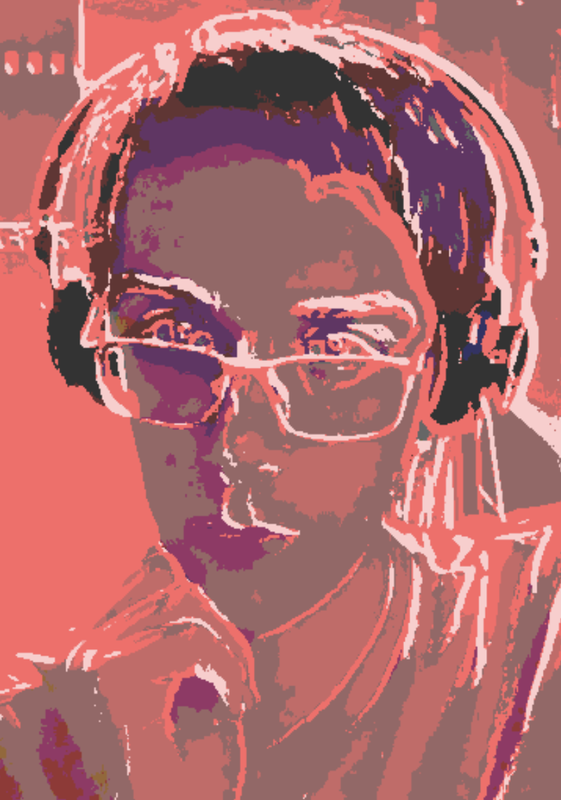 Young man wearing glasses and headphones with his hand raised to his chin.